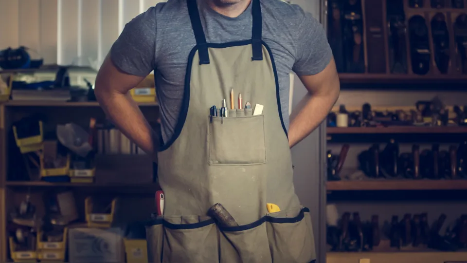 Carpenter wearing a work apron in a workshop