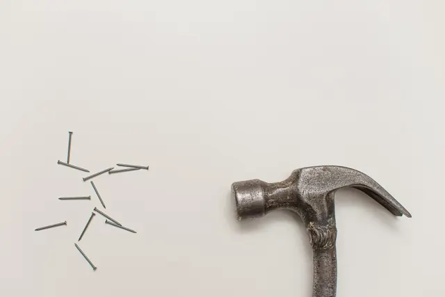 Claw hammer and nails on a light background