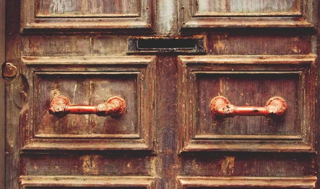 Paneled wooden double door with metal handles