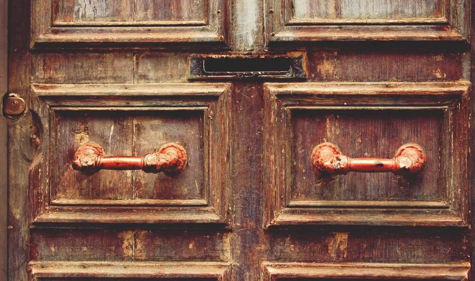 Paneled wooden double door with metal handles