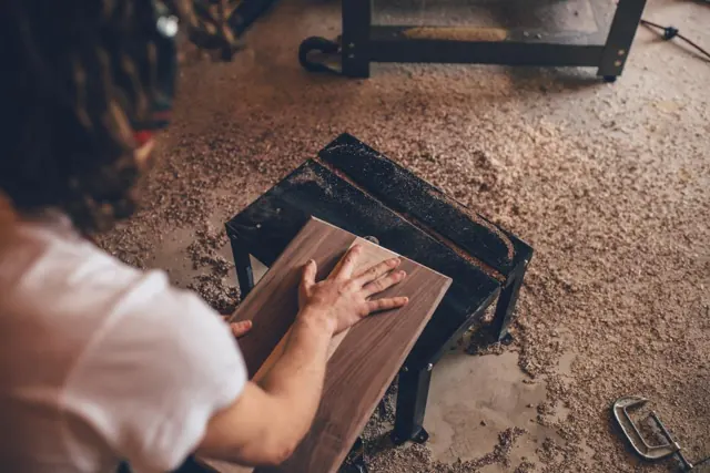 Craftswoman finishing a wooden panel